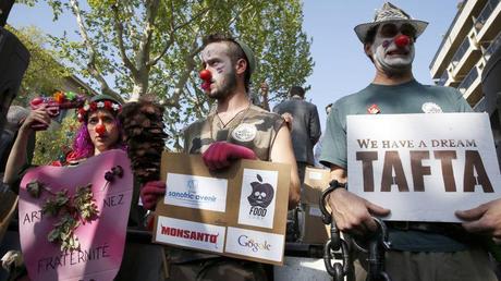 Des militants dénoncent les accords transatlantiques en cours de négociation entre la Commission européenne et les États-Unis à Paris en avril 2014. Crédits photo: PATRICK KOVARIK/AFP