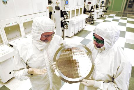 Michael Liehr (left) of SUNY Polytechnic Institute and Bala Haran of IBM Research inspect a wafer of 7 nm node test chips in a cleanroom in Albany, NY. (Courtesy: Darryl Bautista/Feature Photo Service for IBM)