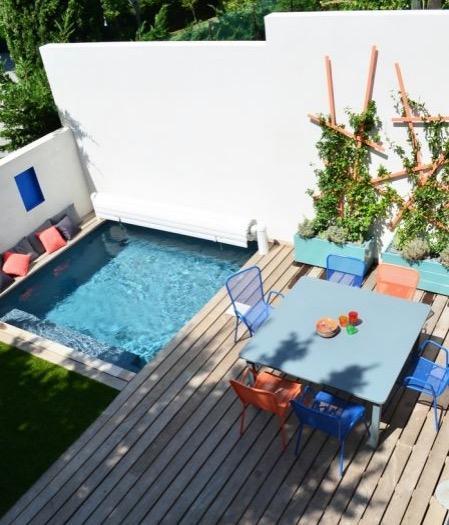 Petite piscine carrée et terrasse colorée.