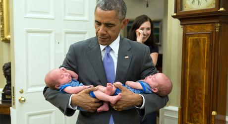 Le président porte les deux petits jumeaux d'une employée du service des Affaires juridiques.
