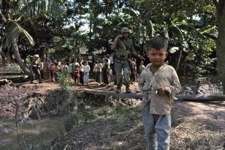 Soldat américain entouré d'enfants vietnamiens, dont un fumant une cigarette, au premier plan, dans le delta du Mékong, lors de la guerre du Vietnam, en octobre 1967. ©Gilles Caron/Fondation Gilles Caron/ Gamma-Rapho
