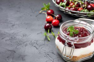 cheesecake in a glass jar with cherries