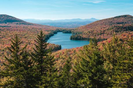 In this October 2014 photo provided by Scott McCracken, breathtaking fall foliage in Groton State Forest in Vermont is shown from Owls Head Mountain. Kettle Pond is seen in the distance. (Scott McCracken/www.scottmccracken.net via AP)