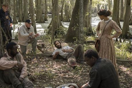 BTS: Gary Ross rehearses a scene in the Knight Company camp set with Gugu Mbatha-Raw, Donald Watkins, and others