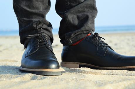 Chaussures derby SUBTLE en cuir noire avec un jean noir délavé et des chaussettes rouge