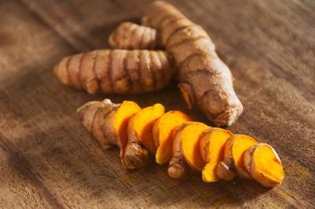Close-up of turmeric or yellow ginger on chopping board