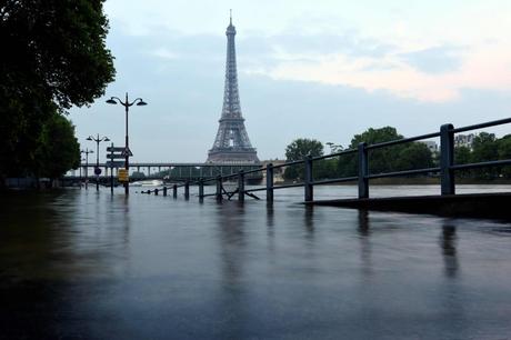 A photo taken on June 5, 2016 shows the lighted Eiffel Tower in front of the Seine river in front Beaugrenelle in Paris. Parisians were urged to stay away from the Seine, which has spilled over its banks in places and on June 3, 2016 rose 6.07 metres (19ft 9ins) above its normal level. Authorities said the river could swell to 