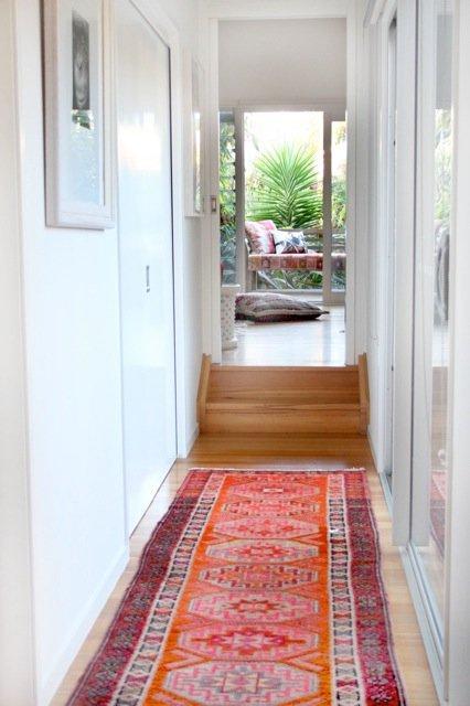ambiance cosy et chaleureuse dans le couloir grâce à un tapis coloré persan rouge