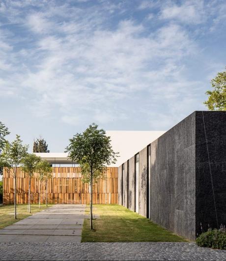 mur de granit maison transparente en verre