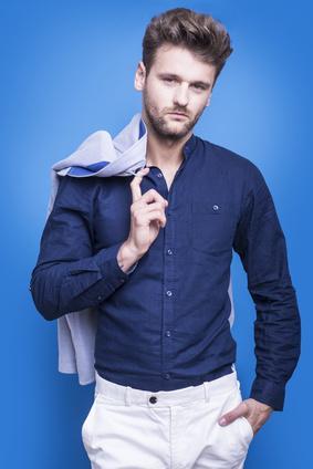 Handsome man in a dark blue shirt on a blue background_115062699_XS