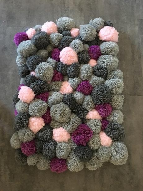Un tapis en pompons de laine pour nos douces soirées d’hiver Un tapis en pompons de laine pour nos douces soirées d’hiver