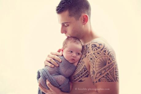 bébé dans les bras de son papa pompier