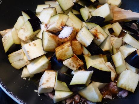  Ajoutez les aubergines, les sauces soja, l'eau et le sucre.
