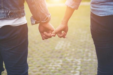 Les bracelets distance, signification et utilisation couple qui se tient la main avec un bracelet distance