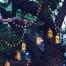 Des lanternes accrochées dans les arbres, comme suspendues grâce à un fil de nylon transparent... avec des guirlandes de lumières LED... pour une ambianca tamisée et magique !