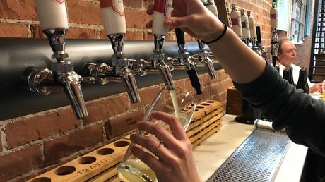 On voit une main verser de la bière dedans.