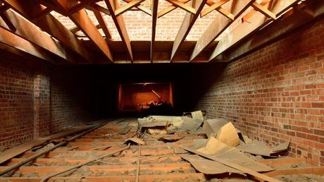 Une pièce en rénovation où l'on voit des poutres et de la mousse isolante.