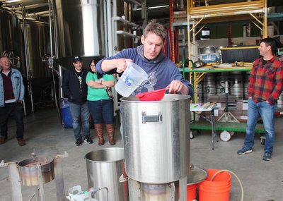 Adam Lewis ajoute lentement de l'eau à un lot expérimental de bière brassée dans un style de dunkel munichois au Breton Brewing.