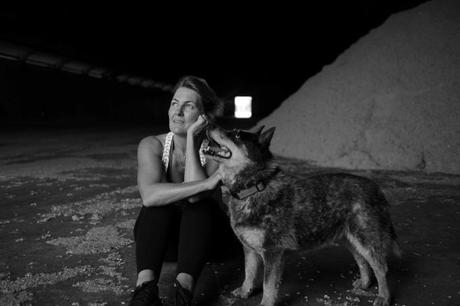 Une image en noir et blanc d'une femme assise avec un chien