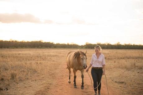 Shanna Whan Femme, debout, cheval, paddock, lumière coucher soleil