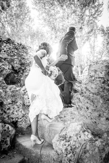 Le marié prend la main de la mariée et l'emmène en haut de marches abruptes.