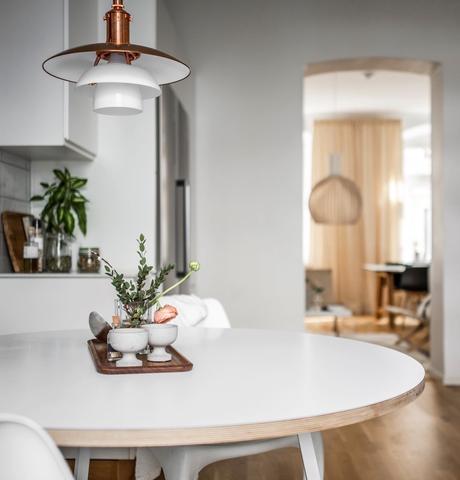 Visite d’un appartement familial dans le quartier de Linné à Göteborg cuisine Linné table ronde blanche repas suspension nordique cuivre - clem around the corner