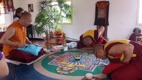 moines bouddhistes réalisant un mandala de sable