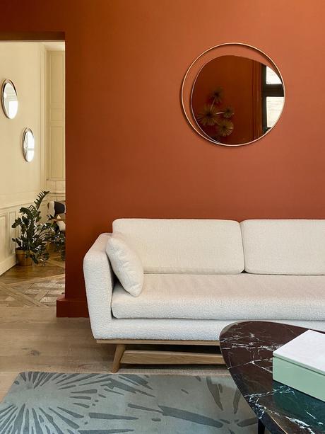 salon canapé bouclette gris clair mur orange terracotta peinture table basse marbre ovale