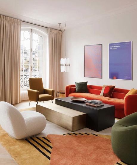 salon coloré rétro canapé orange fauteuil vert blanc tapis motifs géométrique table salon rectangulaire