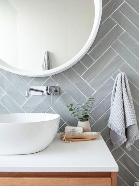 Apportez de la géométrie avec la décoration chevron salle de bain lumineuse mur gris perle miroir rond lavabo ovale blanc