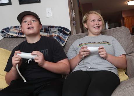 Mackenzie McLain, 15 ans, à droite, et son frère Connor, 12 ans, jouent à un jeu vidéo chez eux le mercredi 2 juin 2021 à Tallmadge, Ohio.  Mackenzie est l'un des 90 étudiants qui rejoindront un club d'esports à l'école secondaire Tallmadge.