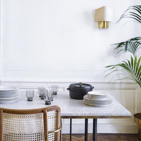 salle à manger table terrazzo petit carreaux noir et blanc chaise cannage bois mur moulure blanc