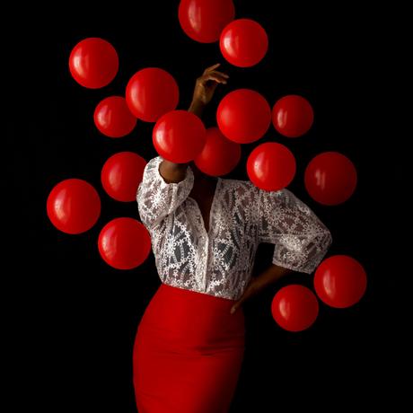 Des grappes de ballons brillants enveloppent la photographe Fares Micue dans ses autoportraits expressifs