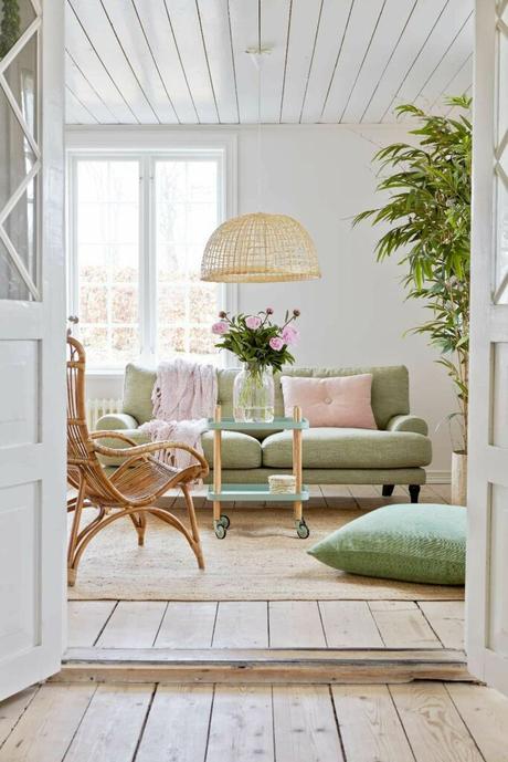 séjour lumineux canapé vert menthe coussin rose pastel fauteuil osier déco douce vintage