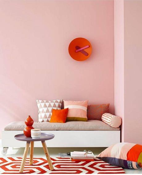 salon coin lecture printanier mur rose pastel coussins orange