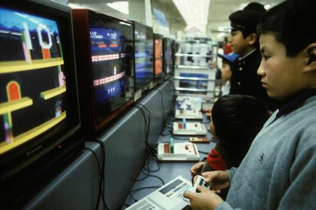 Comment une nouvelle catégorie d’investisseurs motivés par la nostalgie et la chasse aux liquidités ont propulsé le marché du jeu vidéo sur une orbite élevée Enfants jouant à des jeux vidéo Nintendo Famicon en avril 1986 au Japon. Photo de Kaku KURITA/Gamma-Rapho via Getty Images.