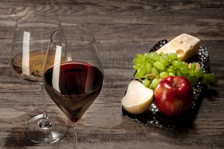 A bottle and glasses of red and white wine with fruits A bottle and glasses of red and white wine with fruits