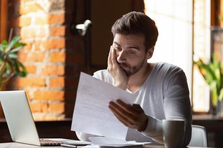 homme bouleversé en regardant les factures