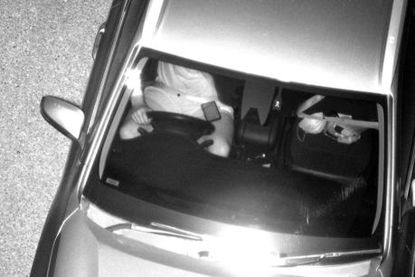 L'homme a utilisé un téléphone portable en conduisant dans une image en noir et blanc prise par un nouvel appareil photo.