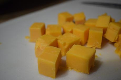 Cubes de fromage cheddar sur une assiette blanche.