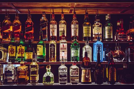 Bases, conseils et astuces du barman étagères avec liqueurs dans un bar sombre