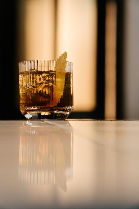 boisson whisky à l'ancienne dans un verre doublé sur un comptoir avec garniture