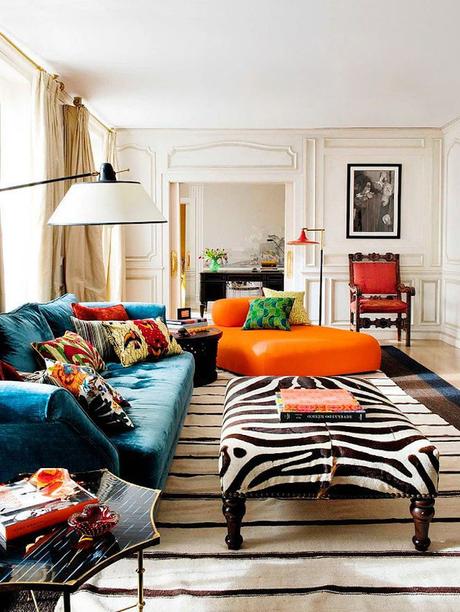salon lumineux style éclectique canapé velours bleu canard fauteuil orange tapis rayé blanc noir