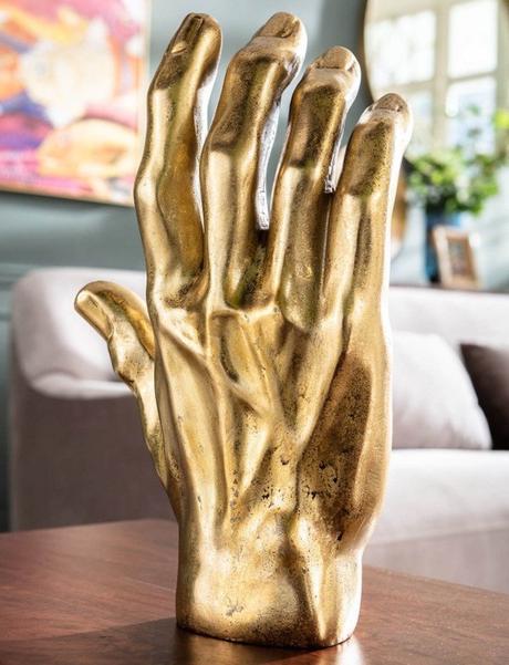 sculpture main dorée decoration intérieure chic salon canapé gris