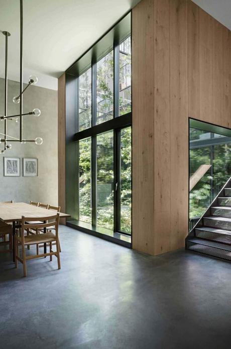 Le style brutaliste dans l’architecture, le design et la déco cuisine salle à manger lumineux table bois rectangle lustre laiton baies vitrées
