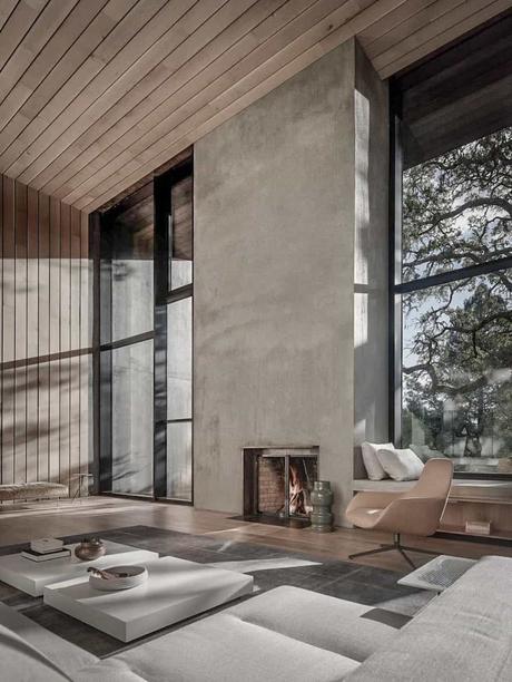 salon spacieux cheminée mur béton sol bois mobilier plat blanc