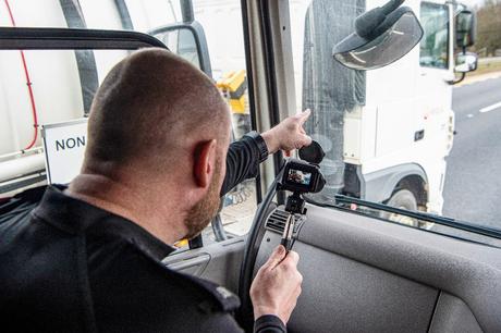 Policier sur le siège passager d'un supercab montrant des preuves de conduite dangereuse sur autoroute