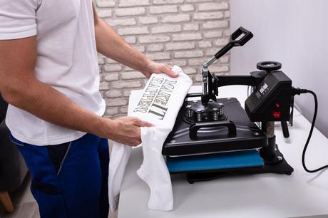 homme utilisant une machine à floquer les t-shirts