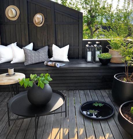 terrasse grise anthracite bois banquette plante verte coussin blanc jardin extérieur