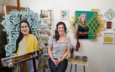 L'artiste de Columbus Kirsta Niemie Benedetti, posant à côté de deux de ses peintures, organisera une exposition d'art de portraits de femmes immigrées américaines qui ouvrira le 4 août à l'espace des arts urbains de l'Ohio State University.